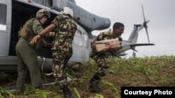 Marinir AS membantu tentara Nepal menurunkan bantuan kemanusiaan dari helikopter korps marinir AS, UH-1Y (11/5). 