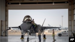 FILE - In this Aug. 5, 2019, photo released by the U.S. Air Force, an F-35 fighter jet pilot and crew prepare for a mission at Al-Dhafra Air Base in the United Arab Emirates.