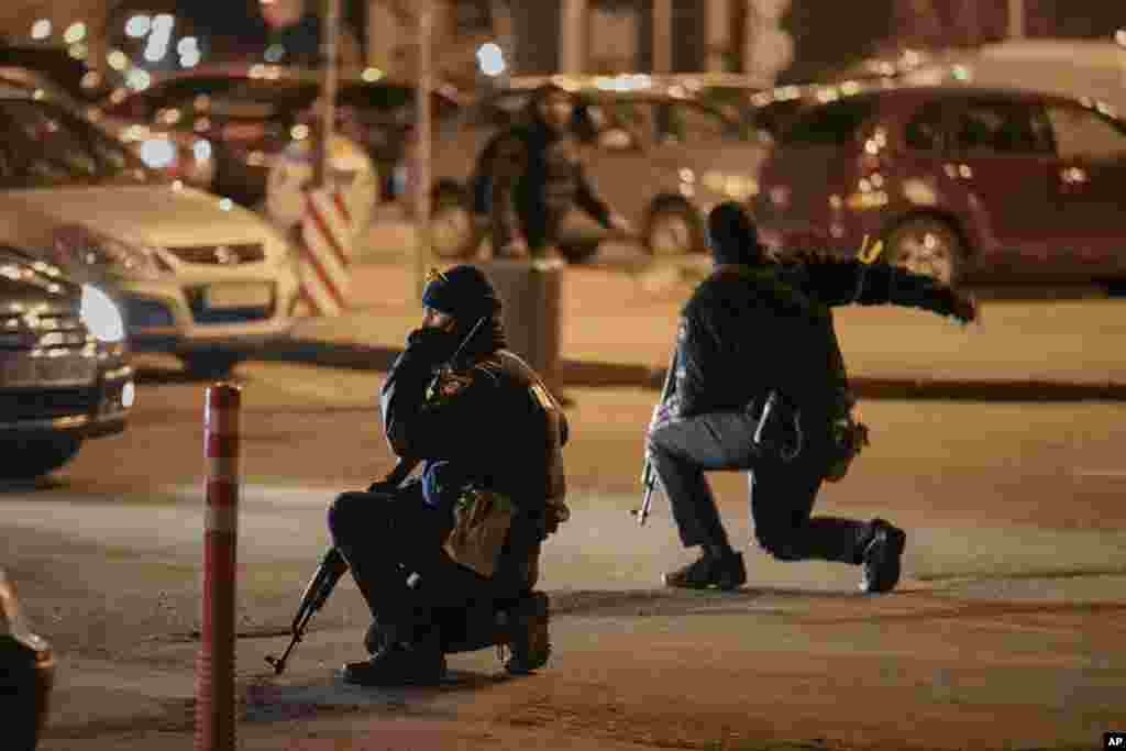 Ukrainian police rush a traveler to the railway station terminal during an airstrike alarm in Kyiv, Feb. 28, 2022.