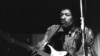 Jimi Hendrix memainkan gitarnya dalam tur di Jerman di Rheinhalle, Dusseldorf, 14 Januari 1969. (AP/Hinninger)
