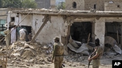 Pakistani men check the damage caused by a car bomb explosion at the site in the town of Darra Adam Khel in the troubled Khyber Pakhtunkhwa province bordering Afghanistan, October 13, 2012. 
