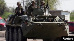 Pasukan keamanan Ukraina mengendarai tank di pos pemeriksaan dekat Slovyansk di bagian timur Ukraina, 4 Mei 2014. 