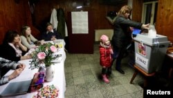 A woman casts her vote during the country's direct presidential election, at a polling station located in a pub in Prague, the Czech Republic, Jan. 12, 2018. 