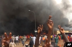 Markas besar partai yang berkuasa terlihat terbakar di tengah demonstrasi para pendukung tentara pemberontak di Niamey, Niger, Kamis, 27 Juli 2023. (Foto: AP)