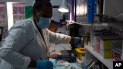 Laboratory technicians test a blood sample for HIV infection at the Reproductive Health and HIV Institute (RHI) in Johannesburg, Nov. 26 2020.