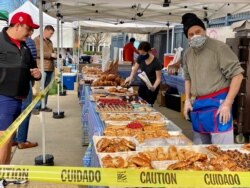 A vendor offers pastries at a stall in the Dupont Circle Market in Washington, D.C., April 5, 2020. Small US businesses have applied for more than $5.4 billion in government-backed loans as part of the country's coronavirus relief plan.