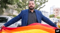 Aktivis LGBT Tunisia, Mounir Baatour, memegang bendera pelangi setelah mendaftarkan pencalonannya sebagai capres dalam pilpres di Tunis, Tunisia, 8 Agustus 2019. (Foto: AP)