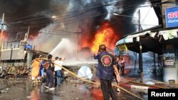 Rescue workers extinguish a fire at the site of a bomb blast in southern Thailand's Yala province, April 6, 2014.