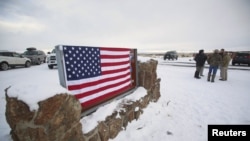 Un drapeau américain couvre un panneau à l'entrée de la Réserve faunique nationale de Malheur près de Burns, Oregon, 3 janvier 2016.