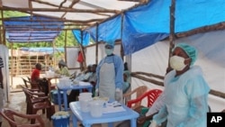 In this photo taken on Sunday, July 27, 2014, Medical personnel inside a clinic taking care of Ebola patients in the Kenema District on the outskirts of Kenema, Sierra Leone. Liberia President Ellen Johnson Sirleaf has closed some border crossings and o