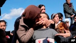 Dilbar Ali Ravu, 10, is kissed by his aunt Dalal Ravu after Yazidi children were reunited with their families in Iraq after five years of captivity with the Islamic State group, March 2, 2019. 
