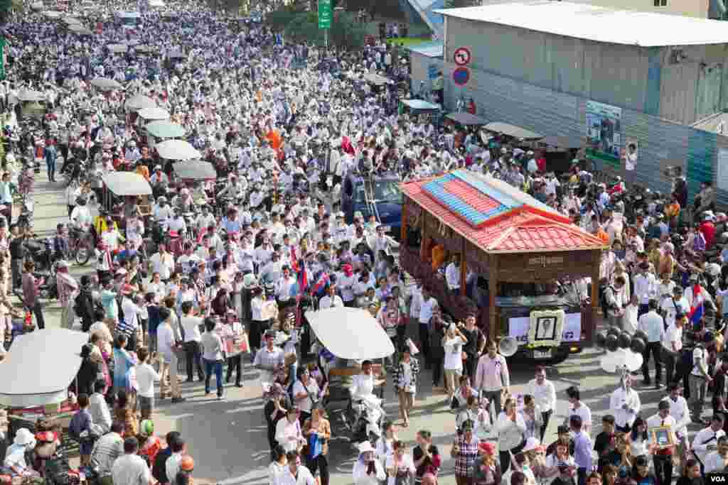 ប្រជាពលរដ្ឋរាប់ម៉ឺននាក់ចូលរួមជូនដំណើរលោក កែម ឡី នៅថ្ងៃអាទិត្យ ទី២៤ ខែកក្កដា ឆ្នាំ២០១៦នេះ។ សពអ្នកវិភាគនយោបាយឯករាជ្យលោក កែម ឡី ត្រូវយកទៅបូជានៅឯស្រុកកំណើតរបស់លោកនៅស្រុកត្រាំកក់ ខេត្តតាកែវ កាលពីព្រឹកថ្ងៃអាទិត្យ។ លោក កែម ឡី ត្រូវឃាតករបាញ់សម្លាប់នៅថ្ងៃទី ១០កក្ដដា កន្លងទៅនេះ។ (ឡេង ឡែន/VOA)&nbsp;