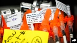 FILE - Syringes filled with Pfizer COVID-19 vaccines sit at the ready at a vaccination clinic at PeaceHealth St. Joseph Medical Center in Bellingham, Wash., June 3, 2021.