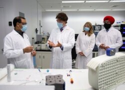 FILE - Canada's PM Justin Trudeau speaks with Krishnaraj Tiwari about vaccines at the National Research Council of Canada in Montreal, Quebec, Canada, Aug. 31, 2020.