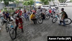 Winners of the Benjamin Canlas Courage to be Kind Foundation get their bicycles at a ceremony in the financial district of Manila, Philippines, July 11, 2020.