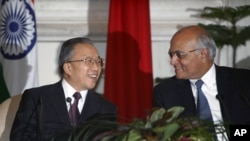 2012年1月17日，中国国务委员戴秉国(左)和印度国家安全顾问梅农在新德里签署一项协议后笑脸相对。