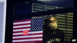 A protester who was arrested waits in the back of a bus during a rally at the Barclays Center over the death of George Floyd, May 29, 2020, in the Brooklyn borough of New York. 