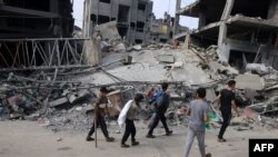 Anak-anak berjalan melewati bangunan yang hancur pasca pemboman Israel di Rafah di Jalur Gaza selatan pada 28 Oktober 2023. (Foto: AFP)