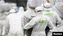 Members of the Japan Self-Defense Forces (JSDF) undergo a quarantine operation at a hog farm after an outbreak of swine fever was detected, in Toyota, Aichi Prefecture, Japan, in this photo taken by Kyodo February 6, 2019. (Kyodo via REUTERS)