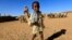 A child carries a bottle of water at a water stop near their shelter at Hajar Al-assal, north of Khartoum on March 19, 2013. 