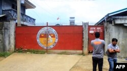 Local government officers stand in front of the gates of the provincial jail in Marawi City, in southern island of Mindanao on August 28, 2016, a day after members of Maute group rescued their jailed colleagues. 
