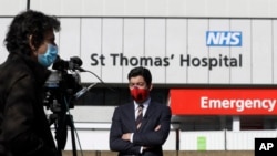 អ្នក​កាសែត​ម្នាក់​ធ្វើ​ការ​នៅ​ខាង​ក្រៅ​មន្ទីរពេទ្យ St Thomas នៅ​ក្នុង​ក្រុង​ឡុងដ៍ កាលពី​ថ្ងៃទី៧ ខែមេសា ឆ្នាំ២០២០។