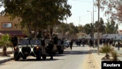 FILE - Security forces keep watch in the southern Tunisian town of Dhiba, near the border with Libya, Feb. 9, 2015. 