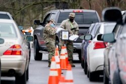 National Guard personnel check in people as they wait to receive a COVID-19 vaccination, Feb. 26, 2021, in Shelbyville, Tennessee.