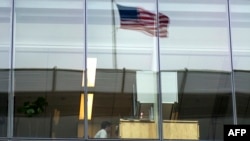 FILE - This file photo taken on May 05, 2016 shows an office worker sitting at his desk at a bank in Washington, DC. Millennials, those who reached adulthood around the year 2000, want to work a less rigid schedule, which could mean the end of the fixed 40-hour work week.