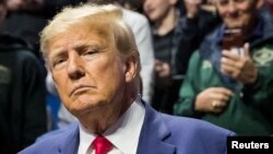 Mantan Presiden AS Donald Trump menyapa para penggemar saat ia tiba di final Kejuaraan Gulat Divisi I NCAA di BOK Center di Tulsa, Oklahoma, AS, 18 Maret 2023. (Foto: Brett Rojo/USA TODAY Sports via REUTERS)