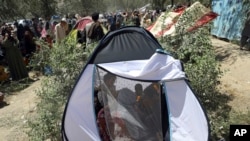 Displaced Afghans from northern provinces, who fled their home due to fighting between the Taliban and Afghan security personnel, take refuge in a public park in Kabul, Afghanistan, Tuesday, Aug. 10, 2021. (AP Photo/Rahmat Gul)