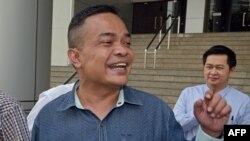 FILE - Jatuporn Prompan (foreground), leader of the Thai opposition "Red Shirt" movement, speaks to supporters at the Criminal Court in Bangkok, Thailand, Jan. 28, 2015.