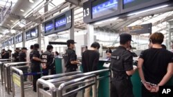 ພາບນີ້ ເປີດເຜີຍໂດຍ ອົງການຂ່າວຊິນຫົວຂອງຈີນ, ໃຫ້ເຫັນພວກຜູ້ຕ້ອງສົງໄສ ຖືກນຳຕົວຜ່ານດ່ານກວດຄົນເຂົ້າເມືອງໂດຍຕຳຫຼວດ ຢູ່ສະໜາມບິນສາກົນ ກວາງຊູ ໄບຢຸນ ໃນເມືອງກວາງຊູ ແຂວງກວາງດົງ ຂອງຈີນ. (Liang Xu/Xinhua via AP)