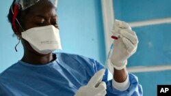 A healthcare worker from the World Health Organization prepares vaccines to give to front line aid workers, in Mbandaka, Dec. 5, 2019 .