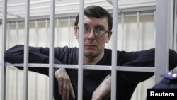 Mantan Mendagri Ukraina Yuriy Lutsenko menatap keluar dari dalam selnya saat berlangsung persidangannya di Kiev, Februari lalu.