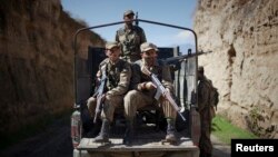 FILE - Pakistani soldiers keep guard along a road in Damadola, along the Afghan border, March 2, 2010. 