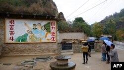 2016年10月22日，在中国陕西省梁家河，中国国家主席习近平青年时期生活过的窑洞外面有一幅描绘青年习近平指引方向的壁画。