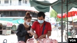 រូបឯកសារ៖ បុរសម្នាក់កំពុងលក់សាច់ជ្រូកក្បែរផ្សារកណ្តាល ខណៈ ផ្សារមិនរៀបរយទូទាំងរាជធានីត្រូវបានបិទ ដើម្បីទប់ស្កាត់ការរីករាលដាលជំងឺកូវីដ១៩ ក្នុងអំឡុងពេលបិទខ្ទប់រាជធានីភ្នំពេញ និងក្រុងតាខ្មៅ ថ្ងៃទី២៦ ខែមេសា ឆ្នាំ២០២១។ (កាន់ វិច្ឆិកា/វីអូអេ)