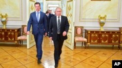 In this photo taken on Tuesday, Oct. 20, 2015, Russian President Vladimir Putin, right, and Syria President Bashar Assad arrive for their meeting in the Kremlin in Moscow, Russia. 