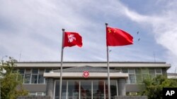 Bendera nasional China dan bendera Hong Kong berkibar di gedung kantor Pemerintah Daerah Administratif Khusus Hong Kong di Beijing, Selasa, 30 Juni 2020. (Foto: AP)