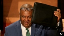 FILE - Sri Lanka's finance minister Mangala Samaraweera, center, shows his folder carrying government's budget proposal for the year 2019 to opposition as he enters the Parliament in Colombo, Sri Lanka, March 5, 2019.