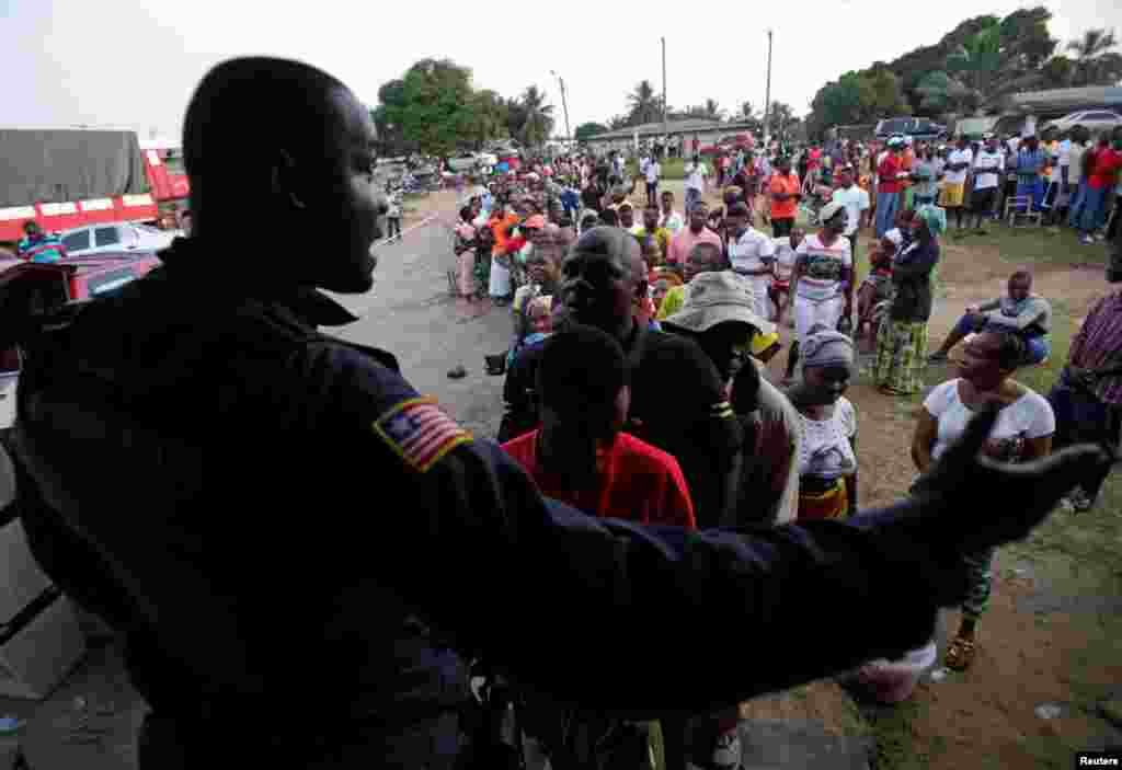 People wait to vote during the presidential election at a polling station of Duport Road in Monrovia, Liberia, Oct. 10, 2017.