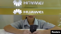 中国湖北省武汉市，一名销售助理在华为展位的柜台后面