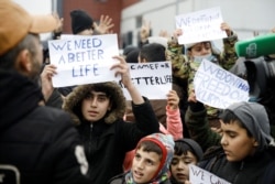 Migrants protest outside the transport and logistics center, Bruzgi, on the Belarusian-Polish border on November 25, 2021. (Kacper Pempel/Reuters)
