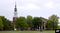 FILE - Students cross The Green in front of the Baker-Berry Library at Dartmouth College in Hanover, N.H., May 22, 2018.