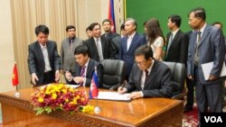 លោក​​ វ៉ា គឹមហុង​ សហ​ប្រធាន​គណៈ​កម្មការ​​ចម្រុះ​កិច្ចការ​ព្រំដែន​កម្ពុជា​វៀត​ណាម និង​​លោក​ Ho Xuan Son (ស៊ូ ស៊ានសឿន​) អនុរដ្ឋមន្ត្រី​ក្រសួងការ​បរទេស​វៀតណាម​​ក្នុង​​ពិធី​​​ចុះ​​ហត្ថលេខា​​លើ់​​ឯកសារ​​មួយ​​ចំនួន​​​នា​ទី​ស្តី​ការ​គណៈរដ្ឋមន្ត្រី​នៅ​ថ្ងៃ​ទី​០៩ ​ខែ​កក្កដា ​ឆ្នាំ២០១៥។ ​(នៅ វណ្ណារិន/VOA) 