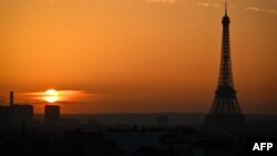 TOPSHOT - This photograph taken on November 4, 2024 shows the sun setting as the silhouetted Eiffel Tower dominates the Paris skyline. (Photo by Christophe DELATTRE / AFP)