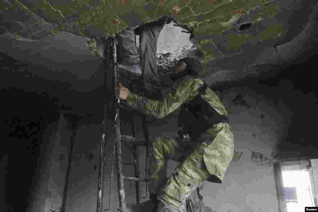 Rebel fighters climb a ladder as they move inside a damaged building where they take positions during clashes with forces loyal to Syria&#39;s President Bashar al-Assad, who are stationed in Aleppo&#39;s historic citadel, Dec. 7, 2014.