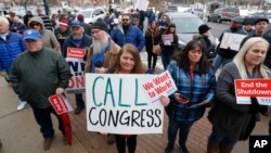 IRS worker Angela Gran, center, and others federal workers protest outside the Federal Building, Jan., 10, 2019, in Ogden, Utah. About 800,000 U.S. federal employees are affected by the government shutdown. (AP Photo/Rick Bowmer)