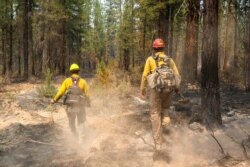 FILE - Firefighters search for hot spots on the northeast side of the Bootleg Fire, near Sprague River, Ore., July 14, 2021.